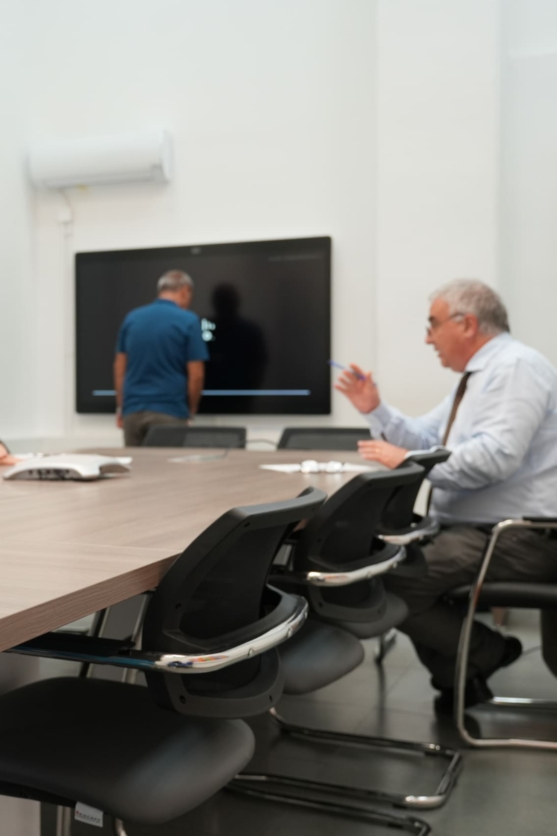 Foto di alcuni dipendenti Sispi a lavoro, mentre si confrontano all'interno dell'aula formazione